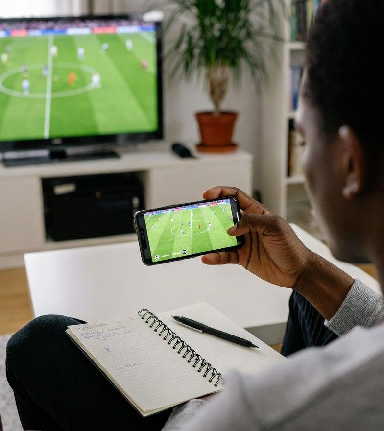 person watching a football match while managing a betting budget